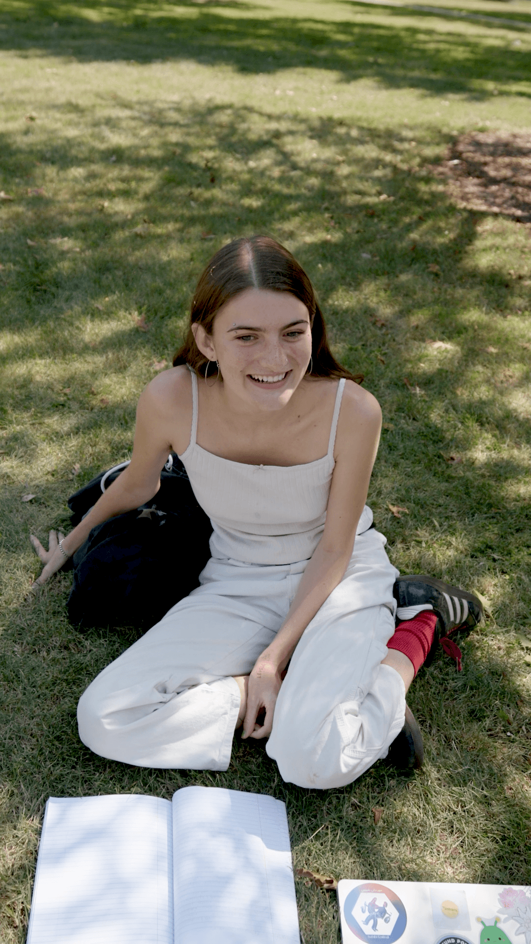 Student creator seated on the grass in the Explain your major Reel